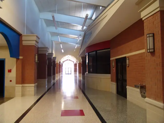 A school corridor with brick walls, a terrazzo floor and freshly finished wall surfaces