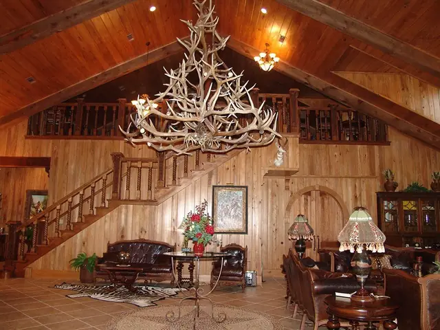 A cabin-style great room with stained wood paneling, staircase and trim finished throughout